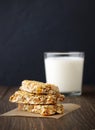 Three granola bars on parchment with milk on rustic wooden background. Royalty Free Stock Photo