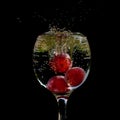 Three grapes falling into a glass of water Royalty Free Stock Photo