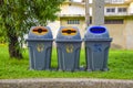 Three gray trash cans located along the path in the park, Throwing garbage into the trash, Please help to keep clean. Houses will