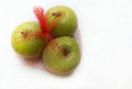 Three green malang apples in red fruit nylon net bag Royalty Free Stock Photo