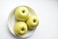 Three green apples on a white plate Royalty Free Stock Photo