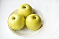 Three green apples on a white plate Royalty Free Stock Photo