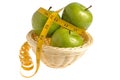 Three green apples wrapped with measuring tape in the wicker basket isolated Royalty Free Stock Photo