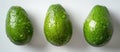 Three green avocados on a white surface Royalty Free Stock Photo