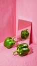 Three green bell peppers with mirror reflection on vibrant pink Royalty Free Stock Photo