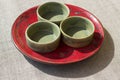 Three green bowls on a red plate, abstraction, background