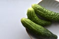 Three green cucumbers on a plate on a white background Royalty Free Stock Photo