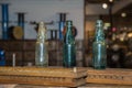 Three Green, Empty and Dirty Glass Bottles on a Wooden Board Royalty Free Stock Photo