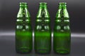 Three green empty glass soda bottles, isolated on black background Royalty Free Stock Photo