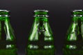 Three green empty glass soda bottles, isolated on black background