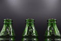 Three green empty glass soda bottles, isolated on black background