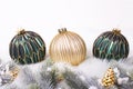 Three green and golden balls, golden pine cones and fir tree branches isolated on white background Royalty Free Stock Photo