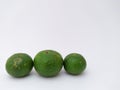 three green kaffir limes in landscape mode on a white background Royalty Free Stock Photo