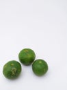 three green kaffir limes in portrait mode on a white background Royalty Free Stock Photo