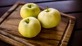 Three green organic healthy apples on wooden board. Royalty Free Stock Photo