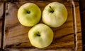 Three green organic healthy apples on wooden board. Royalty Free Stock Photo