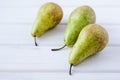 Three green pears on wooden white table Royalty Free Stock Photo
