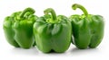 Three green peppers on a white surface