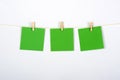 Three green post its on white background hung with small clothespins Royalty Free Stock Photo