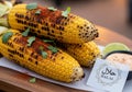 Three grilled corn cobs are generously sprinkled with red chili Royalty Free Stock Photo