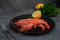 Three 3 grilled giant river prawn on black plate, dark gray stone table. Royalty Free Stock Photo