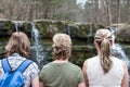 Three grown sisters sitting together by waterfall. Royalty Free Stock Photo