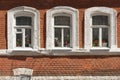 Three grunge windows with red brick wall