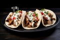 three gyros lined up on a black ceramic plate Royalty Free Stock Photo