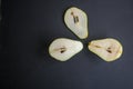 Three half pears on black background