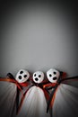 Three halloween ghosts DIY made from white tissue paper, black and orange ribbon on gray background Royalty Free Stock Photo