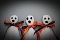 Three halloween ghosts DIY made from white tissue paper, black and orange ribbon on gray background Royalty Free Stock Photo