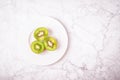 Three halves of ripe kiwies on a white gray marble background. Top view, copy space Royalty Free Stock Photo