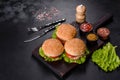 Three hamburger with beef meat burger and fresh vegetables on dark background