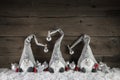 Three handmade gimps on wooden background for christmas decoration in country style.