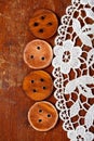 Three handmade wooden buttons on old table and lace Royalty Free Stock Photo