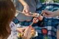 Three hands with chopsticks and sushi. Top view