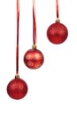 Three hanging Christmas balls on red ribbon over white background Royalty Free Stock Photo