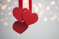 Three hanging red hearts with bokeh