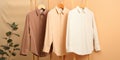 Three hanging shirts in brown, peach, and white colors