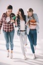 Three happy beautiful girls students with books walking together Royalty Free Stock Photo