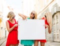 Three happy blonde women with blank white board Royalty Free Stock Photo