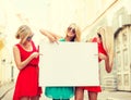 Three happy blonde women with blank white board Royalty Free Stock Photo