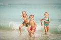 Three happy children playing on the beach