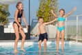 Three happy children playing on the swimming pool at the day tim