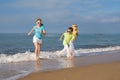 Three happy children running on the beach at the day time. Royalty Free Stock Photo
