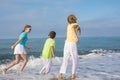 Three happy children running on the beach at the day time. Royalty Free Stock Photo