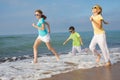 Three happy children running on the beach at the day time. Royalty Free Stock Photo