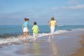 Three happy children running on the beach at the day time. Royalty Free Stock Photo