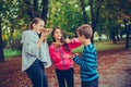 Three happy children talking and eating pizza outdoors, shoving gesture thumb up Royalty Free Stock Photo