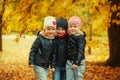 Three happy friends kids hugging and laughing in autumn park Royalty Free Stock Photo